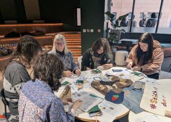 Group of people working on crafts around a table