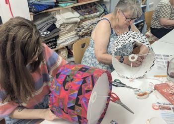 Two people working on individual lamp shade crafts
